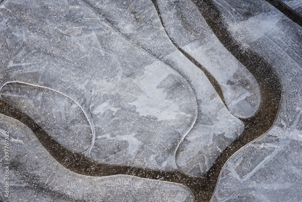 Natural winter abstract background, frozen water with bizarre patterns, macro image