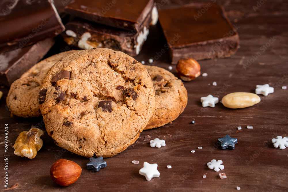 Fototapeta premium Organic food snack tasty sweet dessert milk dark chocolate chip salt cookie closeup piece fruit orange raspberry hazelnut nuts cinnamon on cocoa cacao powder wooden table for new year Christmas gift