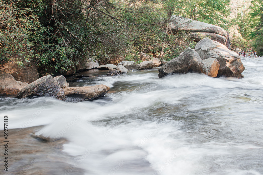 Rapid flow of a mountain river among large rocks in the forest on a sunny summer day. Long Shoals Roadside Park, scenic highway 11 eleven, SC, USA Rapid flow of a mountain river among large rocks in the forest on a sunny summer day. Long Shoals Roadside Park, scenic highway 11 eleven, SC, USA