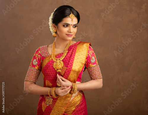 Beautiful Indian young Hindu Bride against brown background in studio shot