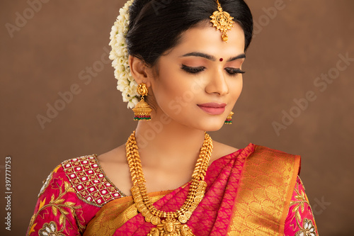 Photography Beautiful Indian young Hindu Bride against brown background in studio shot