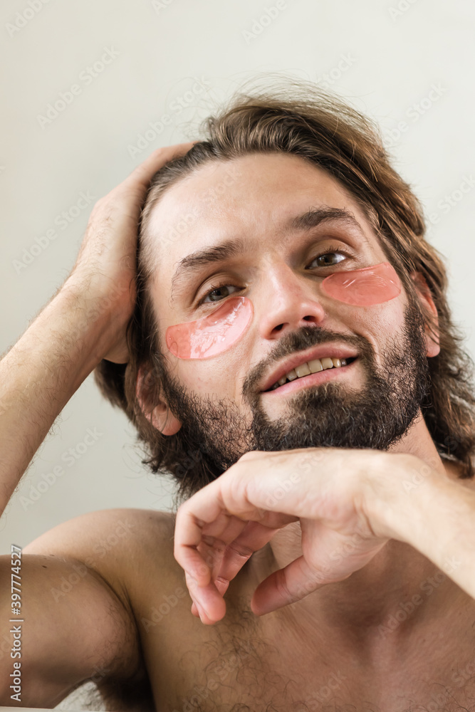 Obraz premium Man face rejuvenating under-eye patch - Masculine skincare beauty routine - Morning Skin Treatment for Men.