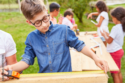 Kind beim Holz messen mit dem Zollstock photo