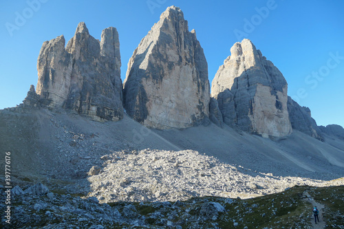 Capture of the Tre Cime di Lavaredo (Drei Zinnen) in Italian Dolomites. The mountains are catching the first sunbeams of the day. There is a lot of landslides. Natural wonder. Discovery and adventure