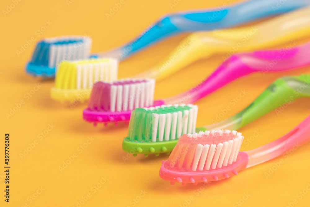Colorful Toothbrushes on yellow background Colorful Toothbrushes on yellow background