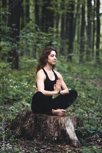 Young girl practices yoga in the forest, the concept of enjoying privacy and concentration © serbogachuk
