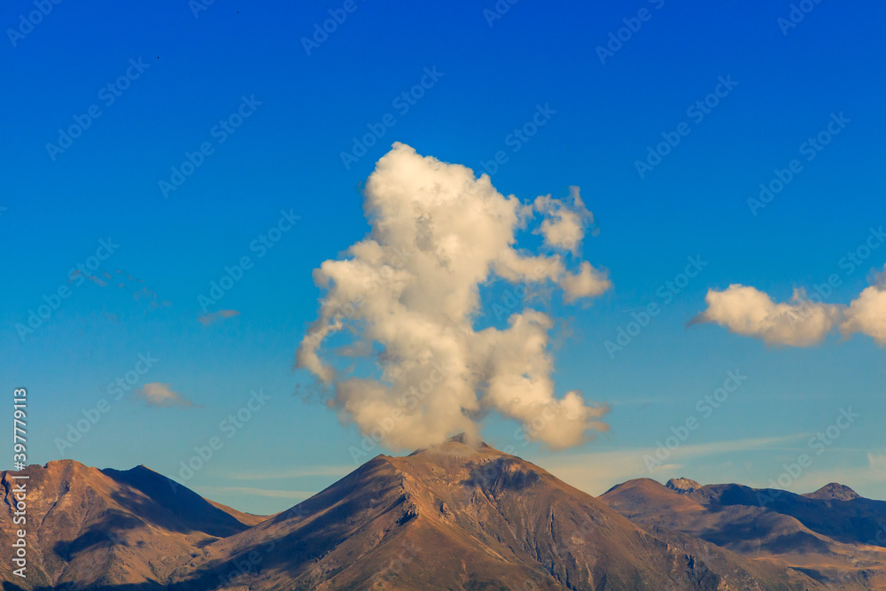 Curious shaped clouds on top of a mountain. Nature elements concept
