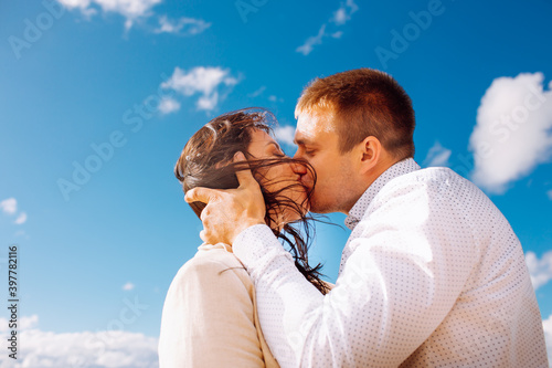 Happy just married middle age couple walk at beach and have fun on summer day and kiss each other