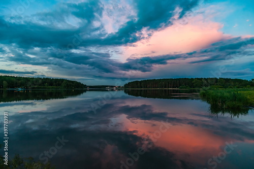 Sunset light in the sky over the lake in the East in summer © Александр Коликов