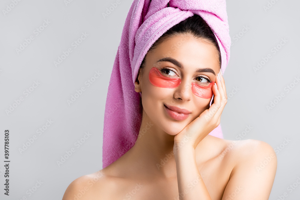 dreamy beautiful woman with towel on hair and hydrogel eye patches on face isolated on grey dreamy beautiful woman with towel on hair and hydrogel eye patches on face isolated on grey
