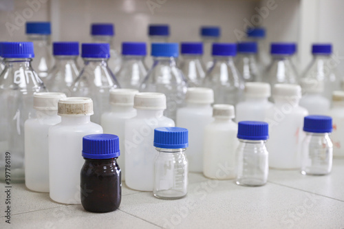 Glass and plastic jars are placed in rows on the table.