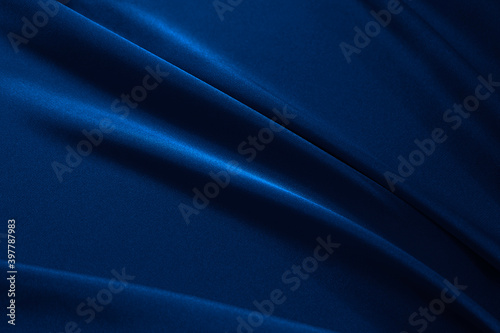 Navy blue elegant abstract background. Silk satin fabric with nice folds. Beautiful dark blue background with wavy lines. Copy space.