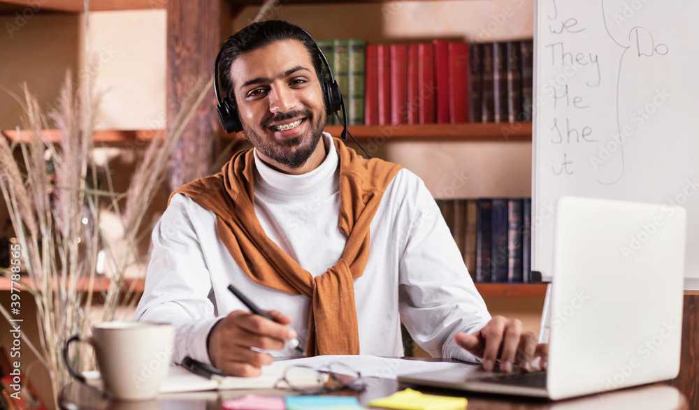Smiling Arab Teacher Sitting At Laptop Posing In Classroom