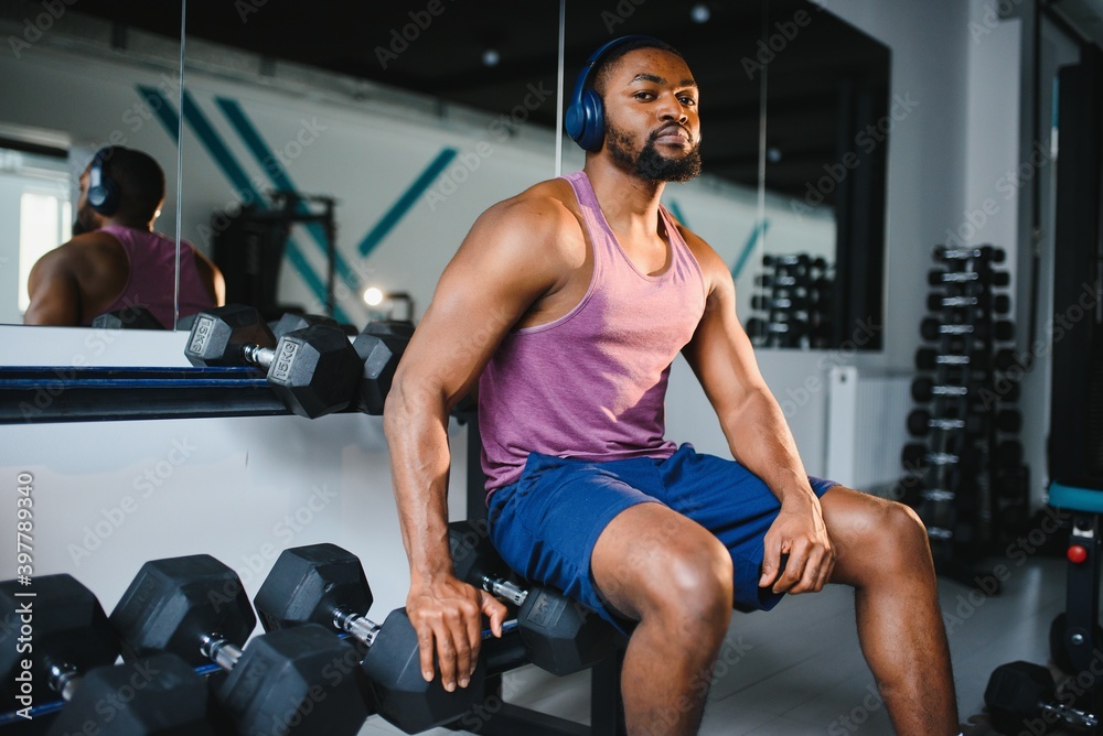 healthy african man working out with dumbbells in gym healthy african man working out with dumbbells in gym