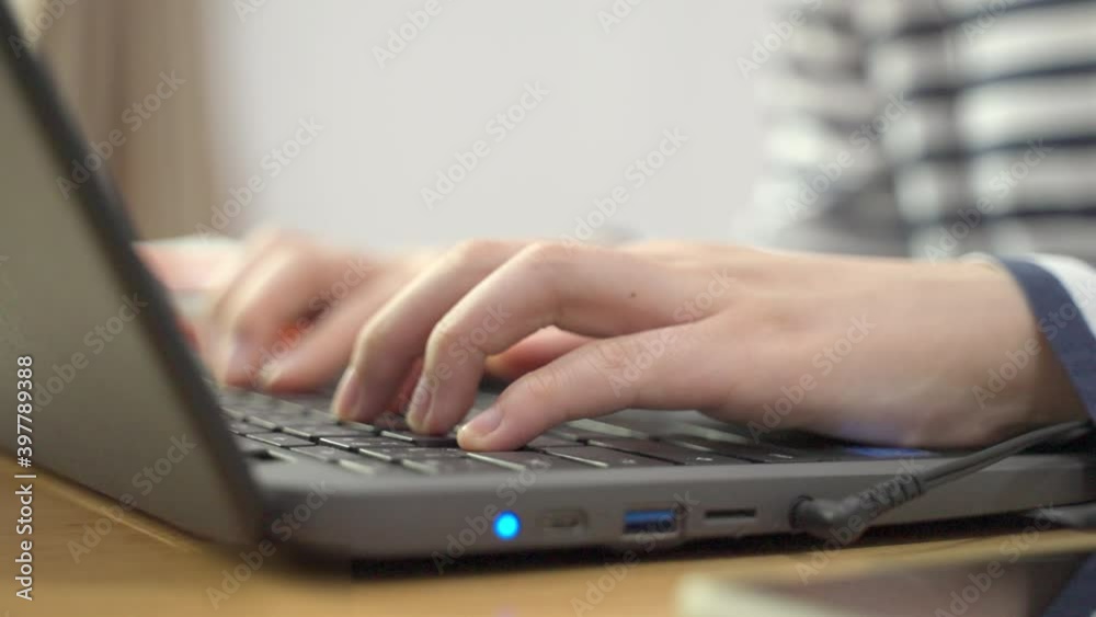 Young woman’s hands typing on her laptop computer’s keyboard in slow motion - working from home concept Young woman’s hands typing on her laptop computer’s keyboard in slow motion - working from home concept