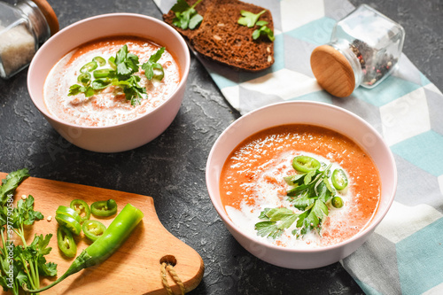 Red lentil tomato soup - delicious vegetarian food on stone background. Healthy lunch