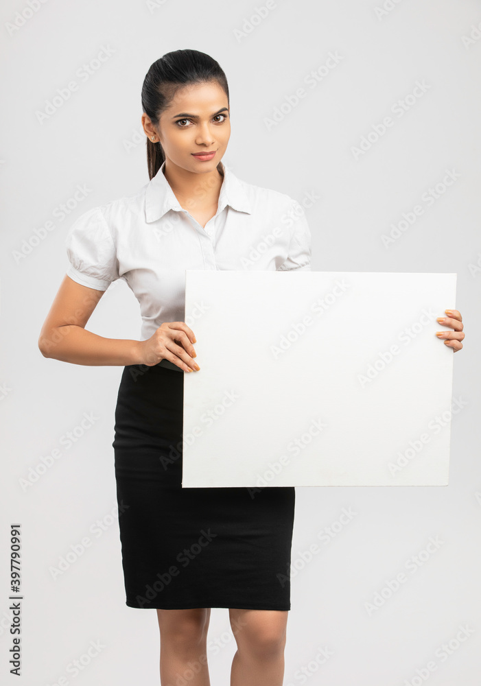 Cheerful attractive young business women holding white board on white. Cheerful attractive young business women holding white board on white.