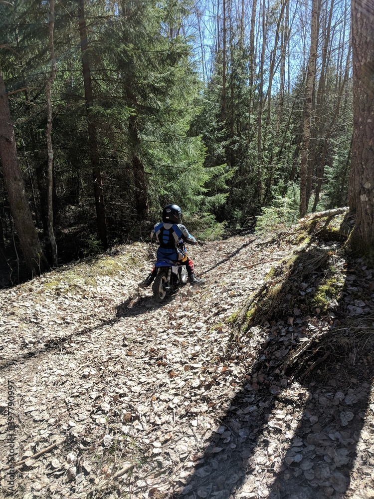Obraz premium A little boy is enjoying his motocross ride in various poses on nature trails.