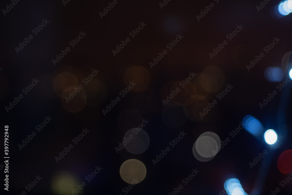 Christmas garland on the window at night. Blur effect and defocus image of illuminated cityscape.