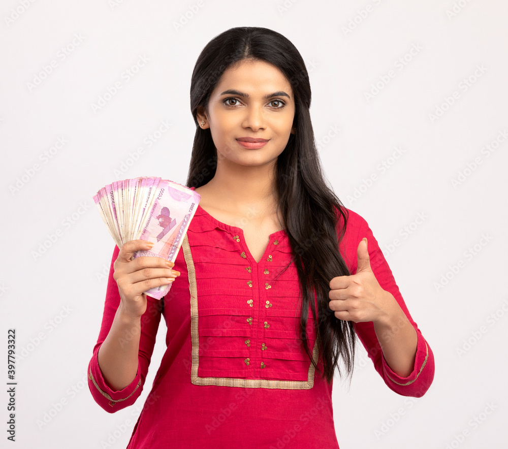 Happy young woman holding Indian 2000 rupee notes on white. Happy young woman holding Indian 2000 rupee notes on white.