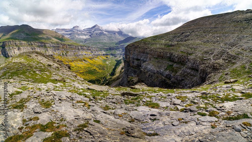 Obraz premium Green landscape in the Pyrenees of the Ordesa and Monte Perdido valley with mountains, rocks, forests and sky with clouds. Top aerial view. 