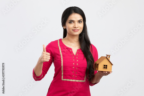 Sticker Cute woman holding an house model on white