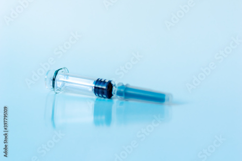 Empty medical syringe for vaccination on a blue background. copy space.
