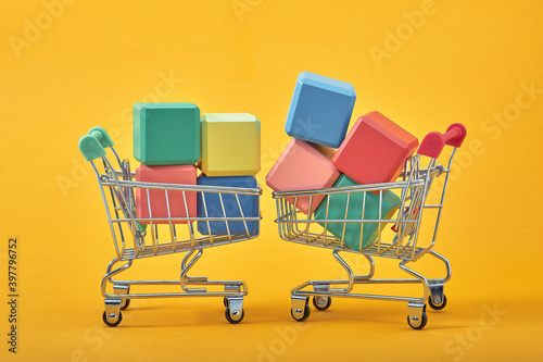 empty wooden cubes mockup style, copy space with shopping trolleys on yellow background. Colourful blocks template for creative design, place for text