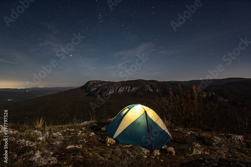Night view of a tourist tent at the edge of a cliff