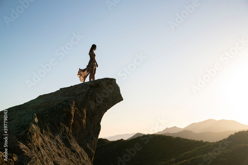 young woman walking on the edge of a cliff in california 