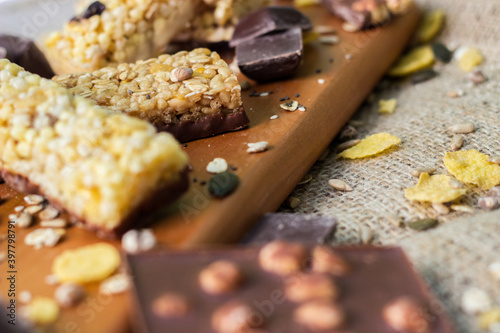 Granola Bars and mixed nuts. Honey bars with peanuts, chocolate, dried fruit, sesame and sunflower seeds