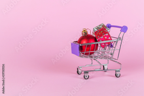 Christmas baubles and gift boxes in shopping trolley. Holiday shopping concept. Winter holiday sales, on-line sale.
