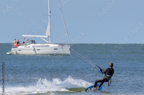 KITSURFER AND SAILBOAT - Active recreation on the water 