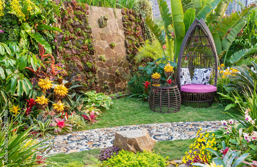 Cozy seat in decorated backyard flower garden