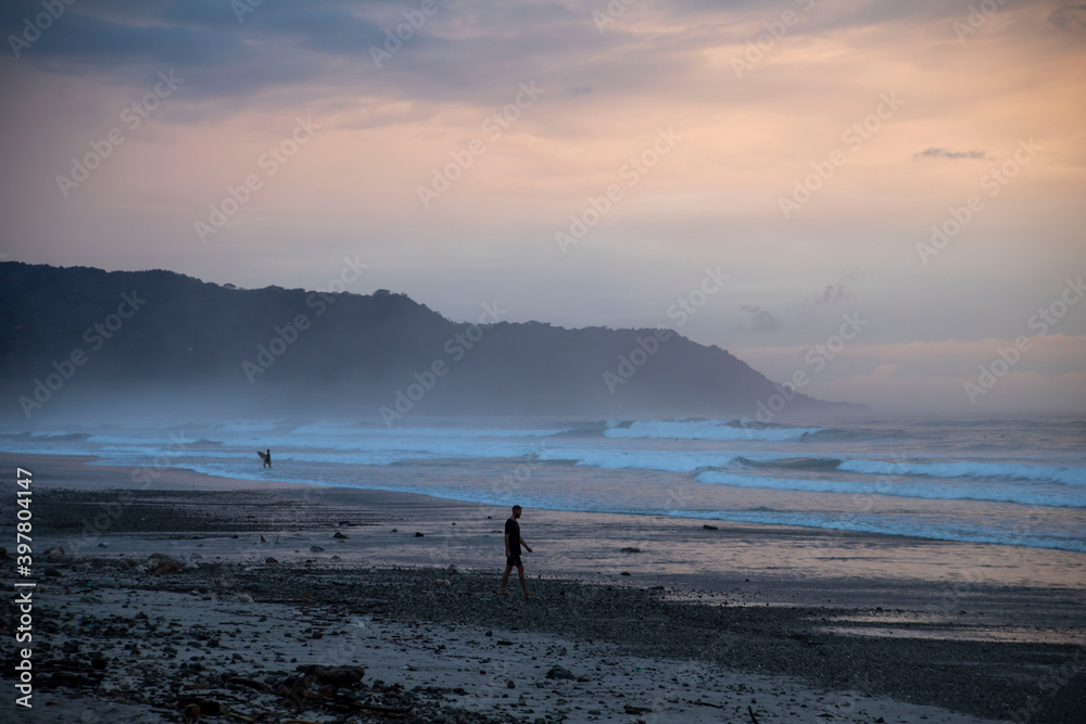 silhouette of man walking towards the beach at sunset in costa rica