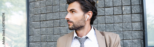 businessman in wireless earphones and suit  banner