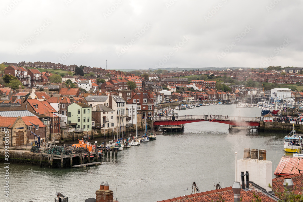 View of Whitby including the river, bridge and old houses in a coastal seaside town, Yorkshire.