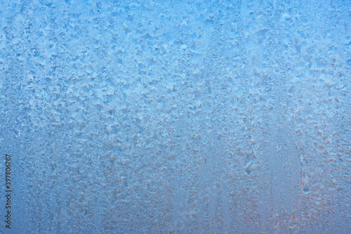 Winter background on a transparent glass of a window with a frozen texture. Abstract texture background, horizontal image, copy space for your design or text