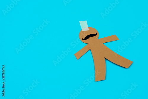 brown paper man doll with a piece of adhesive tape photo