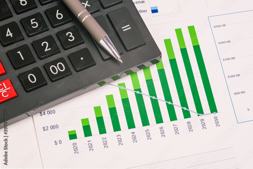 Calculator, chart and pen close up. Stock market analysis. Financial and accounting reporting. Business concept Calculator, chart and pen close up. Stock market analysis. Financial and accounting reporting. Business concept