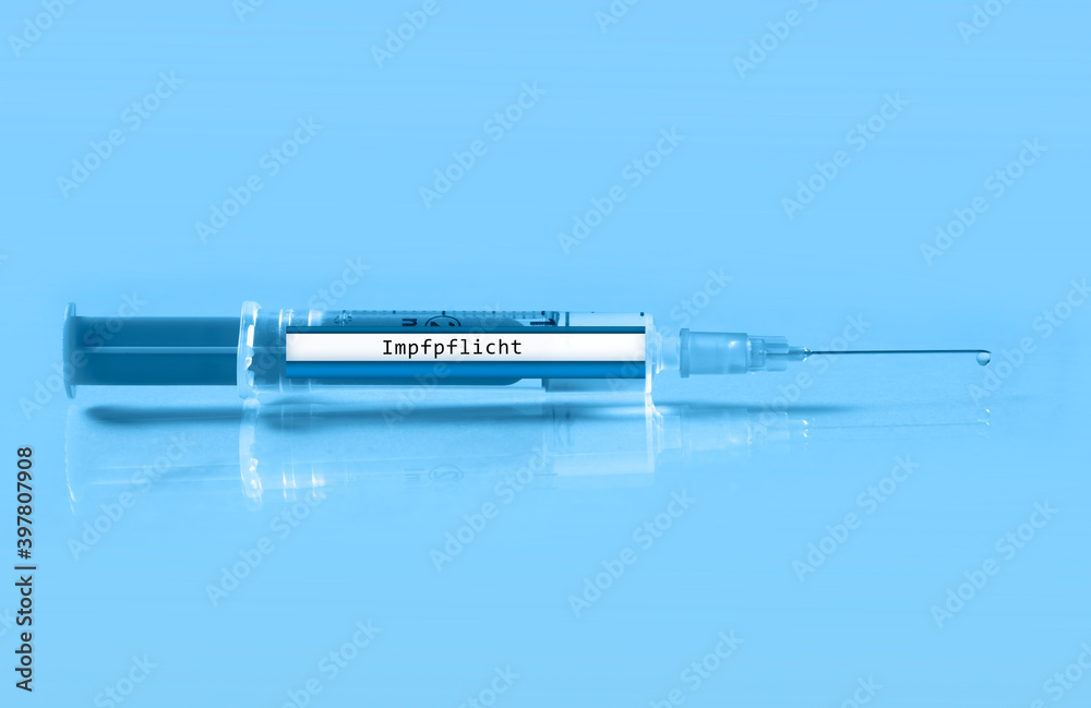 Obraz premium close up of a syringe with the german inscription vaccination obligation