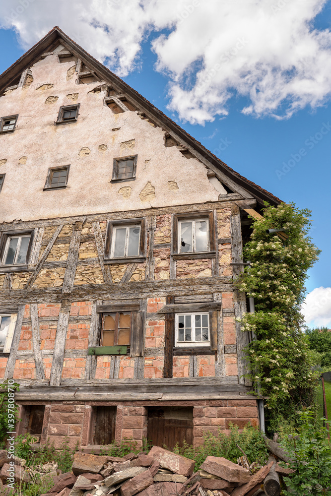 Fassade von einem alten verlassenen Fachwerkhaus mit teils begonnener Renovierung Fassade von einem alten verlassenen Fachwerkhaus mit teils begonnener Renovierung