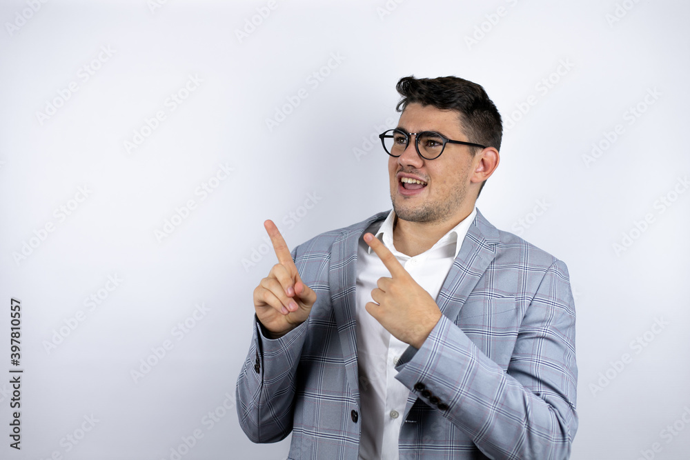 Business young man wearing a casual shirt over white background pointing to the side surprised Business young man wearing a casual shirt over white background pointing to the side surprised