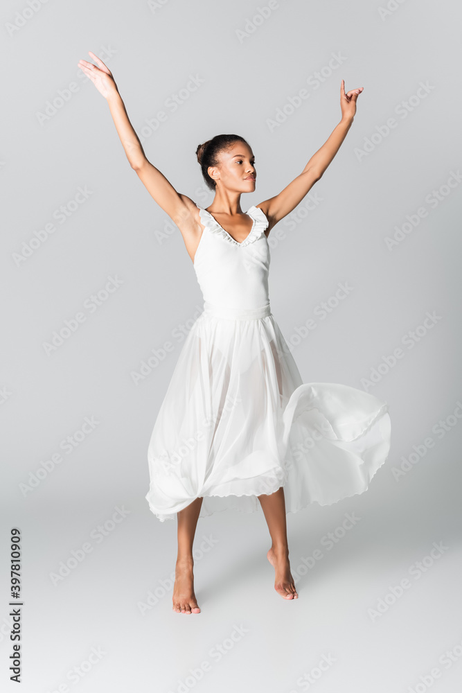 barefoot graceful african american ballerina in dress dancing on white background barefoot graceful african american ballerina in dress dancing on white background