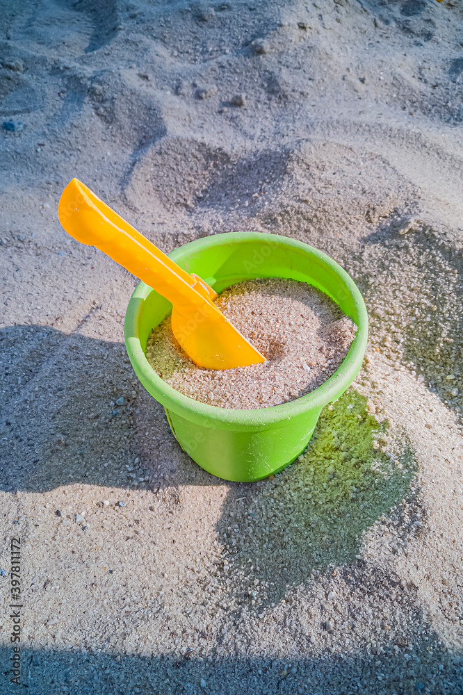 Children's bucket with shovel in sandbox at playground Children's bucket with shovel in sandbox at playground