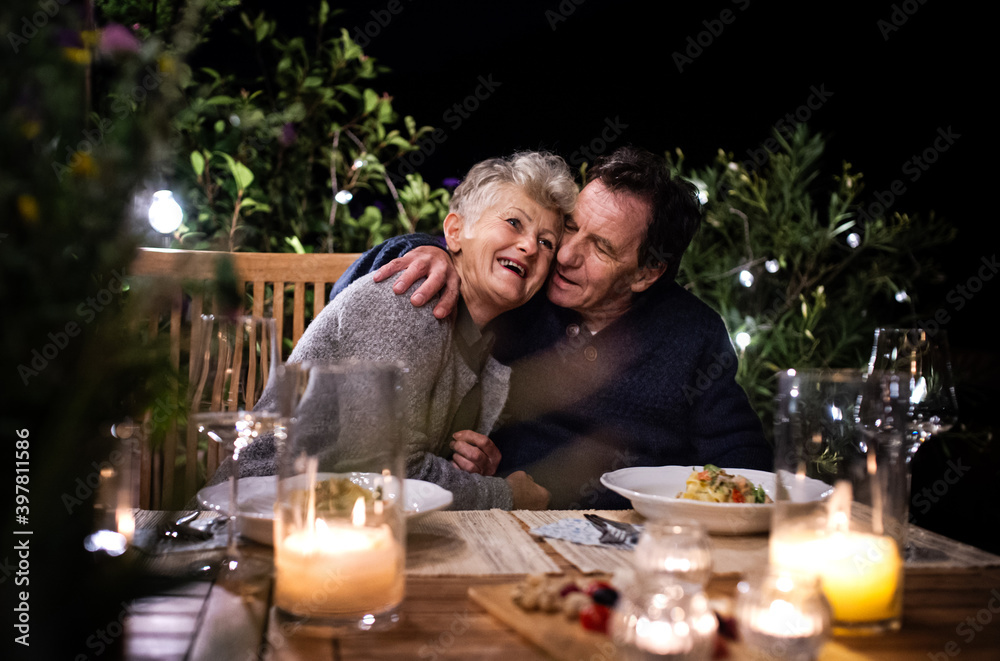 Happy senior couple having dinner in the evening on terrace. Happy senior couple having dinner in the evening on terrace.