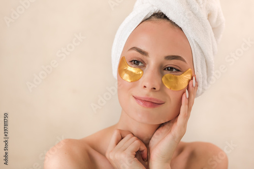 Beauty face woman natural healthy cosmetic skin pure suresh beautiful female happy smile portrait manicure hand. Beauty portrait of an attractive girl with a gold patch under the eyes. photo