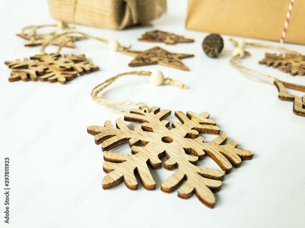 Wooden christmas ornaments, and a pine cone with christmas present boxes on an isolated white surface, front view