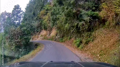 View through dash camera showing SUV driving through narrow, dangerous and curved mountainous roads.