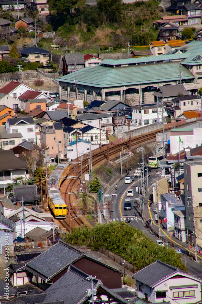 高台から黄色い電車を眺める